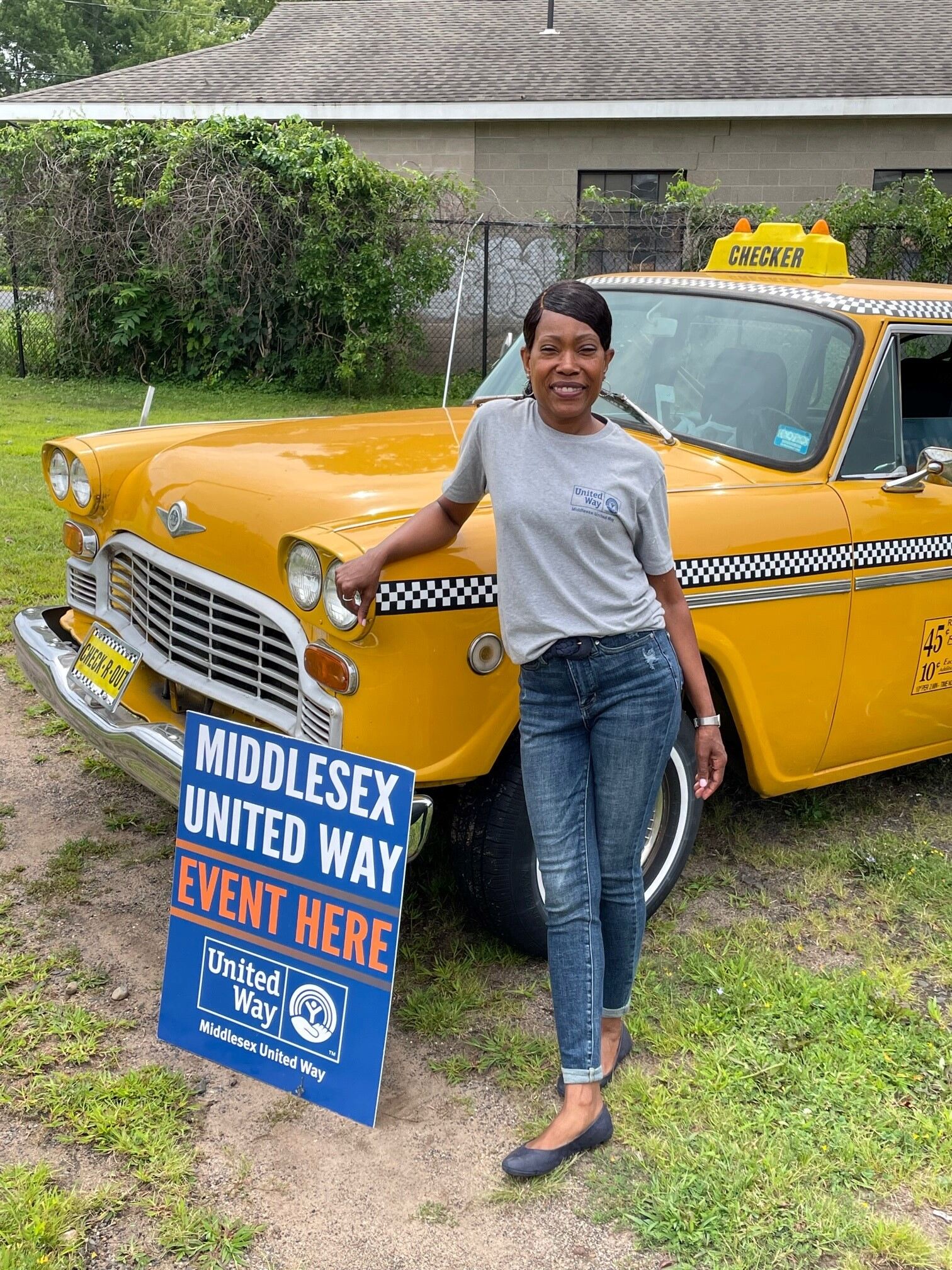 MUW President and CEO, Shawonda S. Swain, poses in front of the taxi.